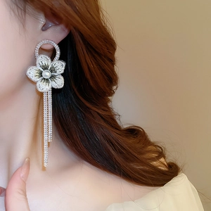 Gros plan de boucles d'oreilles fleurs à pompons avec broderie et cristaux brillants