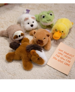 Detailed view of six cute plush animal magnets on a soft rug including capybara and sloth
