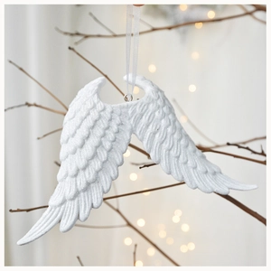 Detail of white resin angel wing ornaments with glitter coating on tree branches