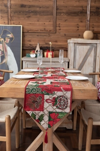 Close-up of jacquard Christmas table runner with red tassels and poinsettia patterns