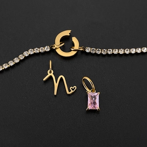 Close-up detail of 14K gold plated chain with pink crystal and letter n heart charm