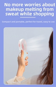 Close-up of portable cat mini fan with white shell and pink blades in outdoor use