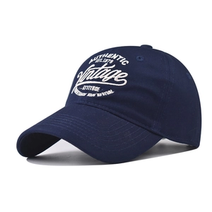 Close-up of vintage embroidery and cotton twill texture on a navy baseball cap