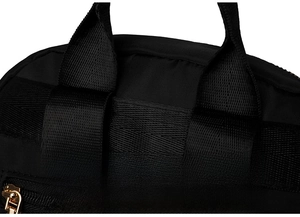 Detail of reinforced stitching on nylon backpack straps with a golden metal zipper