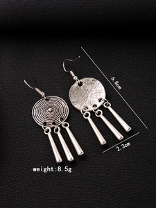 Detail view of ethnic metal fringe earrings with concentric texture and dimensions