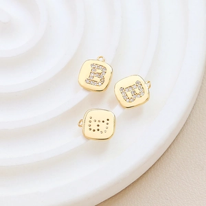 Macro view of gold-plated letter B pendant with zircon inlay for jewelry making