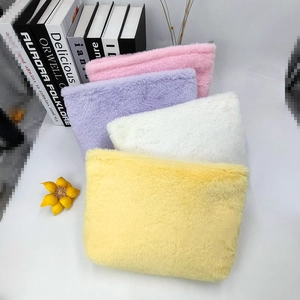 Close-up of fluffy macaron colored plush makeup bags in yellow, white, lilac and pink