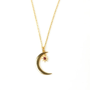 Detail of gold crescent moon necklace featuring a red round zircon star pendant