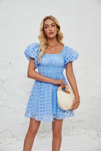 Détail de la robe bleu clair à carreaux avec manches bouffantes et encolure carrée d'été