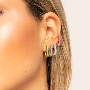Close-up of sparkling colorful zircon tassel earrings in green, purple, blue, and pink gold