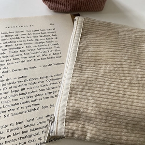 Detailed macro view of a beige corduroy makeup bag with Big star and little moon label