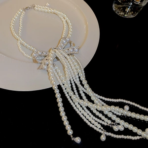 Vue détaillée d'un collier de perles à pampilles avec un nœud serti de diamants brillants
