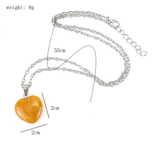 Detail view of a 2cm heart-shaped yellow gemstone pendant with 53cm silver chain and size info