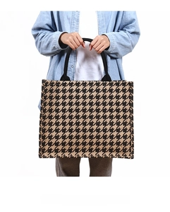 Close-up of houndstooth jute tote bag featuring durable black woven handles and textured linen