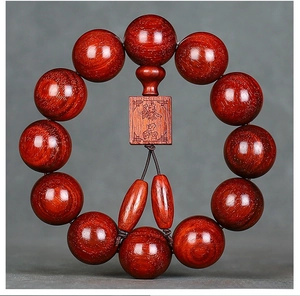 Macro detail of 20mm blood sandalwood prayer beads with engraved plaque and dZi beads