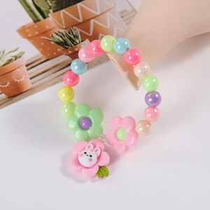 Detail of colorful children's beaded bracelet with cute flower and rabbit charms