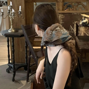 Bohemian floral printed hair scrunchie shown on a ponytail in a vintage setting