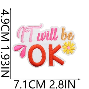 Macro view of 'It will be OK' embroidery patch with daisy and dimension markers