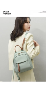 Close-up of mint green Oxford cloth backpack with leather handle on model