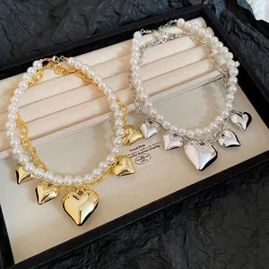 Double-layered pearl and heart pendant necklace in gold and silver finish options