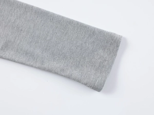 Gros plan détaillé de la double couture et de la texture en maille grise du haut à manches