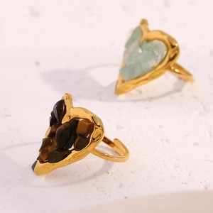 Close-up of heart-shaped tiger eye and aventurine stones set in 18K gold open rings