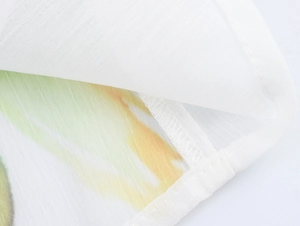 Vue macro d'un tissu mousseline à fleurs avec ourlet roulé délicat et imprimé aquarelle vert