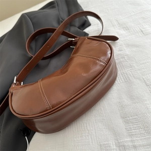Deep brown minimalist hobo bag with oil wax leather texture and adjustable shoulder strap