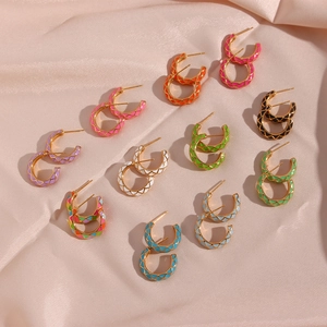 Detail of colorful grid enamel hoop earrings on champagne silk background fabric