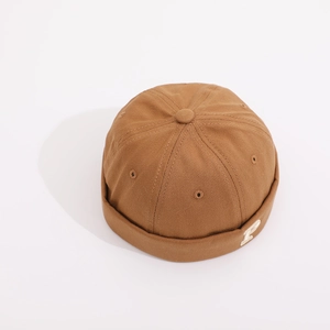 Close-up of brown Docker hat with white letter P embroidery and segmented stitching