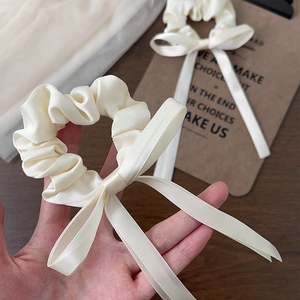 Elegant cream satin bow scrunchie with long ribbons for a sweet hairstyles look