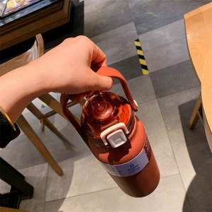 Close-up of orange sports water bottle with handle and 316 stainless steel label