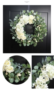 Detail view of artificial rose and eucalyptus wreath on black door with fabric flower texture