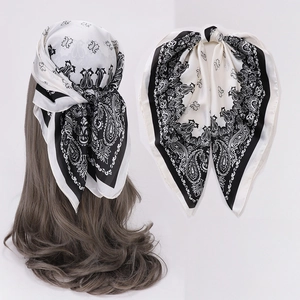 Black and white paisley silk scarf detail showing stylish hair knot and folded texture