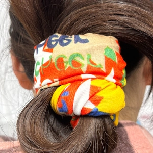 Close-up of a colorful printed fabric headband tied in a hair knot for daily hair styling