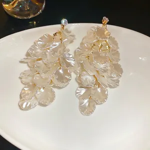 Elegant long tassel earrings featuring layered white shell petals and sparkling rhinestones