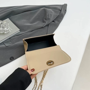 Chic beige quilted crossbody bag with golden clasp and chain strap, interior view