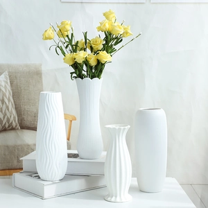 Set of four minimalist white ceramic vases with yellow roses for home living room decor