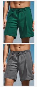 Detail of dark green and grey athletic shorts with breathable mesh and drawstring waist
