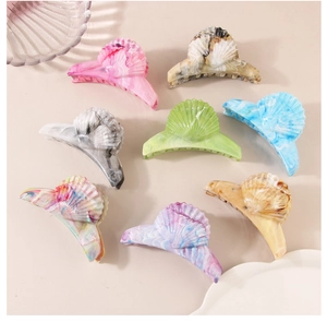 Flat lay of shell-shaped marble pattern hair claws in eight assorted aesthetic colors