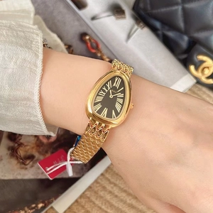 Detail of luxury snake-head watch with gold metal strap and black dial on wrist