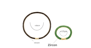Detail view of gold necklace and bracelet set with black and green zircon stones