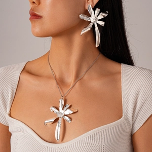 Close-up of elegant silver floral necklace and earring set on a model with metallic finish