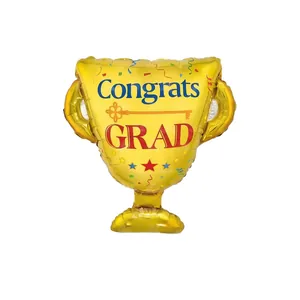 Detail of golden trophy foil balloon with Congrats GRAD print for graduation party decor