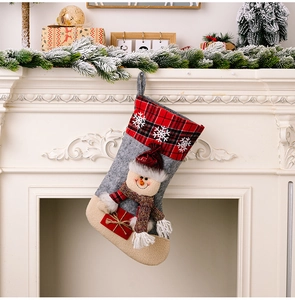 Detail of Christmas stocking with snowman figure hanging on white fireplace decor