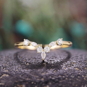 Makroaufnahme von V-förmigem Goldring mit Marquise- und runden Zirkonia in Krallenfassung