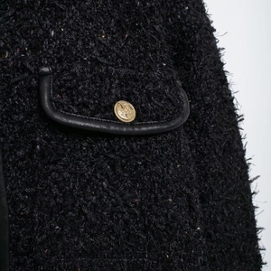 Veste élégante en tweed noir avec poche bordée de cuir et détails de boutons dorés