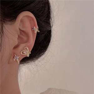 Close-up of gold ear cuff set with purple star and white heart zircon stones on ear
