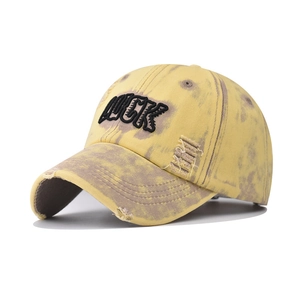 Close-up of vintage washed baseball cap with LUCK embroidery and distressed edges