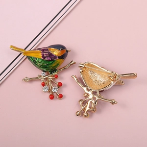 Detailed front and back view of a colorful enamel bird brooch with red berries and rhinestones